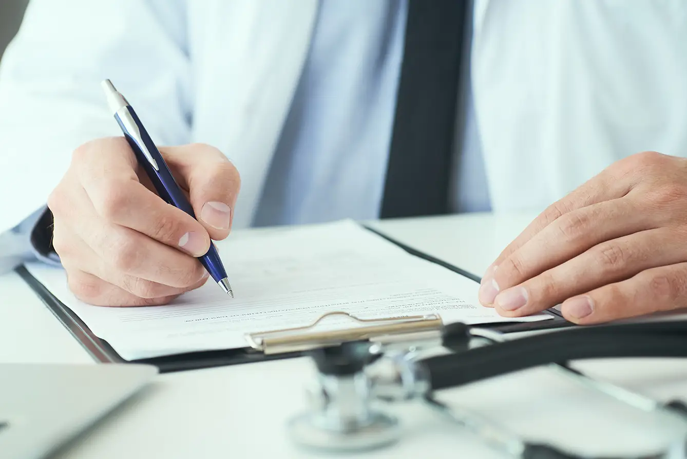 Arzt schreibt medizinisches Gutachten